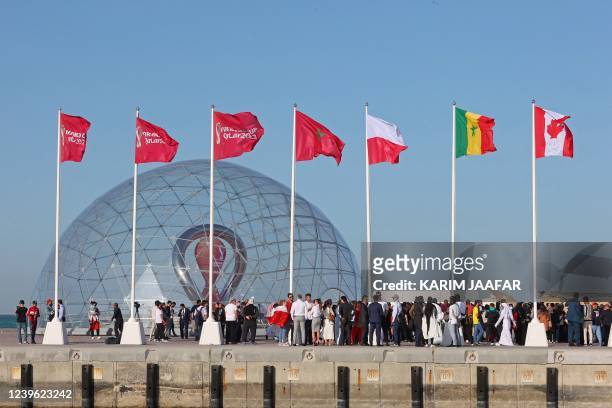 People gather during a flag-raising ceremony of the newly-qualified countries for the 2022 World Cup in the Qatari capital Doha, on March 30, 2022. -...