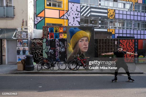 Man rollerskating past various street art on Redchurch Street in Shoreditch on 24th March 2022 in London, United Kingdom. Shoreditch is a fashionable...