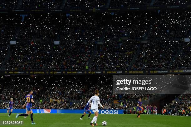 Supporters hold up their smartphone flashes during the women's UEFA Champions League quarter final second leg football match between FC Barcelona and...