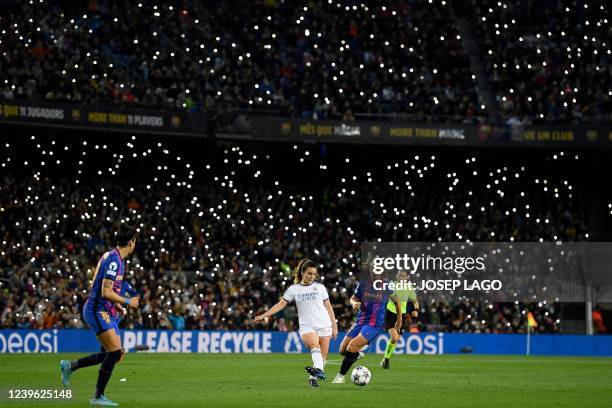 Supporters hold up their smartphone flashes during the women's UEFA Champions League quarter final second leg football match between FC Barcelona and...