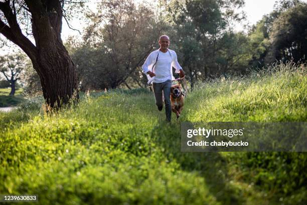 mens die met hond in aard loopt - coolpad stockfoto's en -beelden