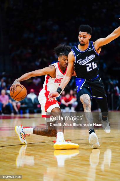 Jalen Green of the Houston Rockets dribbles the ball around Jeremy Lamb of the Sacramento Kings during the game at Toyota Center on March 30, 2022 in...