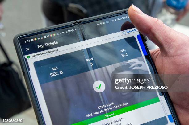 Jose Santos from Texas, holds his tickets to see US comedian Chris Rock at the Wilbur Theatre at a sold out show in Boston, Massachusetts on March...