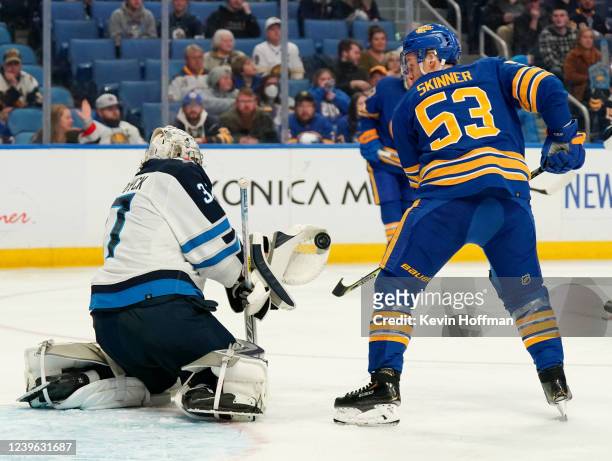 Connor Hellebuyck of the Winnipeg Jets makes a glove save against Jeff Skinner of the Buffalo Sabres during the third period at KeyBank Center on...