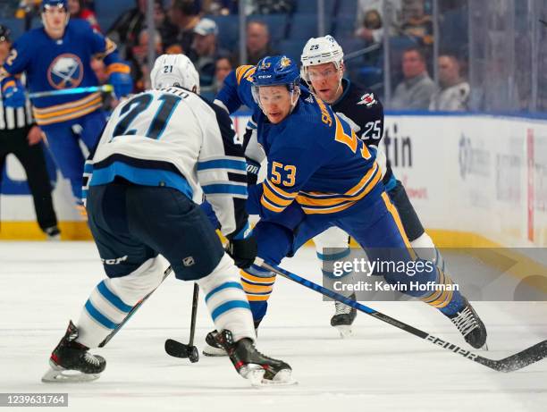 Jeff Skinner of the Buffalo Sabres skates up ice with the puck as Dominic Toninato and Paul Stastny of the Winnipeg Jets defend during the third...