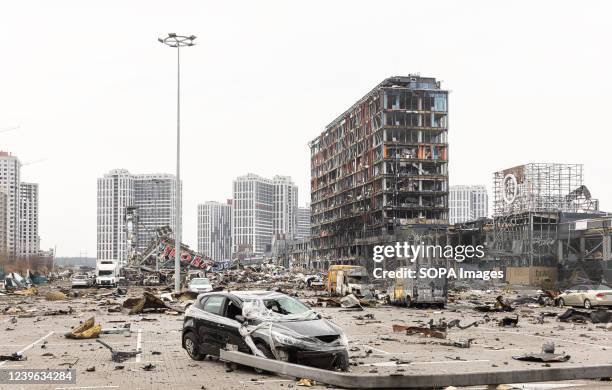 Devastating view of the parking lot with a burnt car near the destroyed Retroville shopping center following the Russian shelling attack. Retroville...