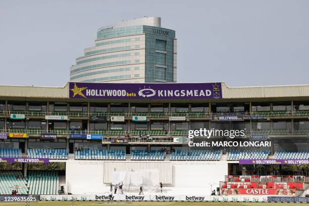 Workers cover the digital sign board with a cover as play has been delayed due to a technical malfunction of the sign board ahead of the first day of...