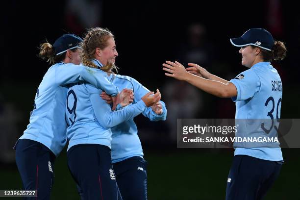 England's Sophie Ecclestone celebrates the wicket of South Africa's Masabata Khaka with teammates during the 2022 Women's Cricket World Cup second...