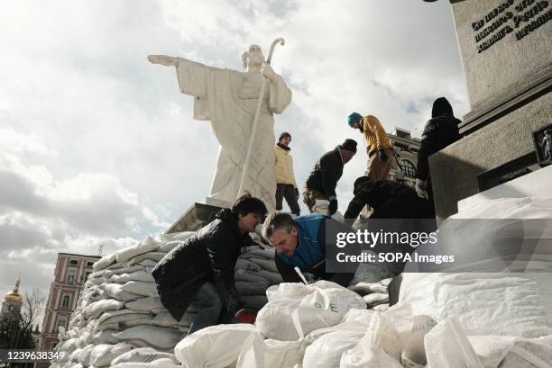 Volunteers and residents place sandbags around a monument to protect it from Russian missiles and shelling damage. As the Russian invasion of Ukraine...