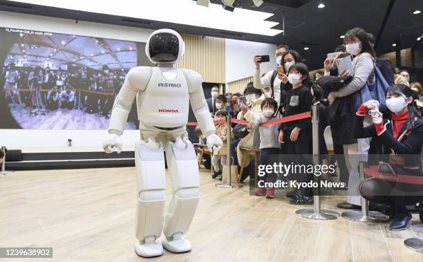 Honda Motor Co.'s ASIMO humanoid robot walks after its final performance in front of about 100 people at a showroom at the company's head office in...