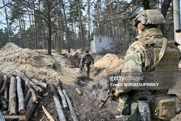 Ukrainian servicemen survey the area from their position along the front line, north of the Ukrainian capital of Kyiv on March 31, 2022. - Kyiv said...
