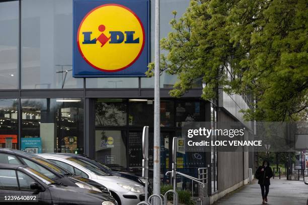 Pedestrian walks past the entrance of a Lidl discount supermarket, in Nantes, on March 31, 2022.