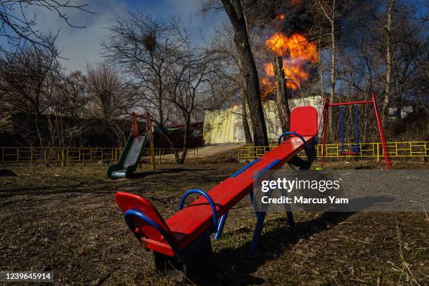 Playground sits behind a building that was just hit by Russian bombardment, and caught on fire, in the Moskovskyi district in Kharkiv, Ukraine,...