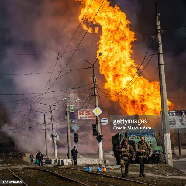 Ukrainian soldiers move away after Russian bombardment destroyed a building near their position, in the Moskovskyi district in Kharkiv, Ukraine,...