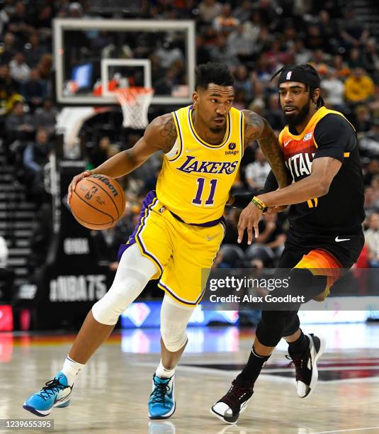 Malik Monk of the Los Angeles Lakers drives past Mike Conley of the Utah Jazz during the first half at Vivint Smart Home Arena on March 31, 2022 in...