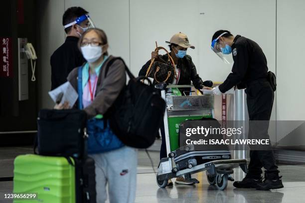 An arriving passenger gets paperwork checked at the Hong Kong International Airport on April 1 after the city lifted a flight ban on nine countries...