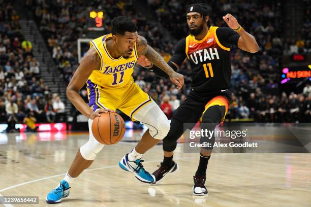 Malik Monk of the Los Angeles Lakers drives against Mike Conley of the Utah Jazz during the first half at Vivint Smart Home Arena on March 31, 2022...