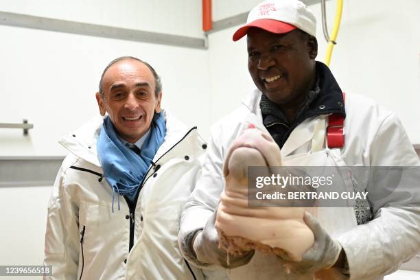 French far-right party Reconquete! presidential candidate Eric Zemmour with an employee at the tripe department of Rungis' market, the biggest fresh...