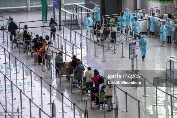 Travelers heading to quarantine in the arrival hall at Hong Kong International Airport in Hong Kong, China, on Friday, April 1, 2022. A ban on...