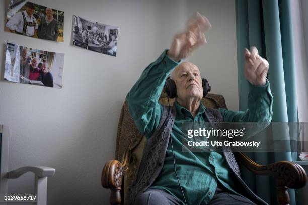 In this photo illustration an old man conducting to music he hears on headphones on March 30, 2022 in Heidelberg, Germany.