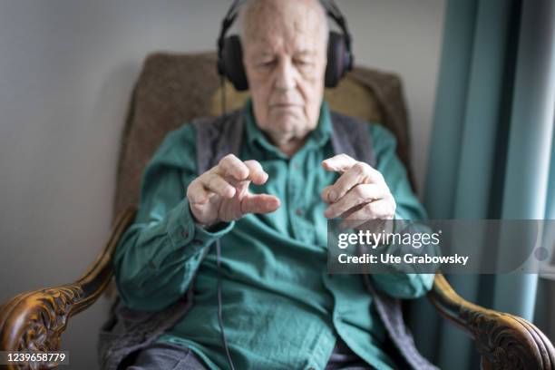 In this photo illustration an old man conducting to music he hears on headphones on March 30, 2022 in Heidelberg, Germany.