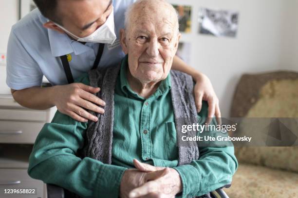 In this photo illustration an old man is happy to be touched by a nurse on March 30, 2022 in Heidelberg, Germany.