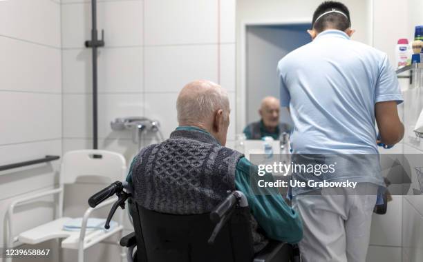 In this photo illustration a geriatric nurse is helping an old man with his body care on March 30, 2022 in Heidelberg, Germany.