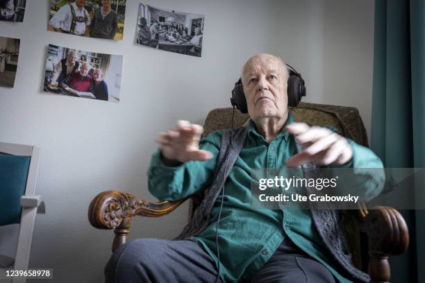 In this photo illustration an old man conducting to music he hears on headphones on March 30, 2022 in Heidelberg, Germany.