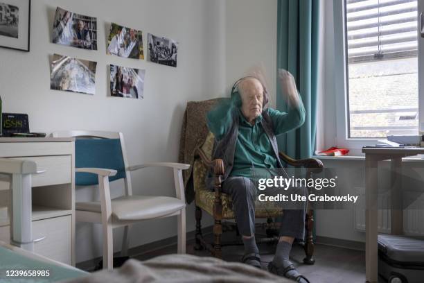 In this photo illustration an old man conducting to music he hears on headphones on March 30, 2022 in Heidelberg, Germany.