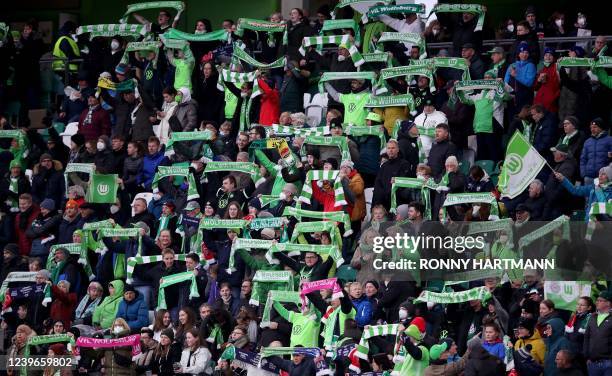 Wolfsburgs supporters cheer with scarfs during the UEFA Women's Champions League quarter-final second leg football match VfL Wolfsburg v Arsenal in...