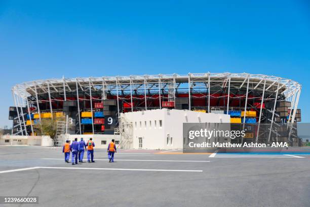 An exterior general view of the Stadium 974 as workers walk towards the stadium, a host venue for the Qatar 2022 FIFA World Cup in Doha. Built on the...