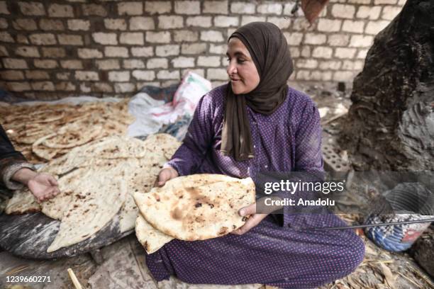 An Egyptian woman, cooking dough in a stone oven, is seen as they continue Ramadan preparations at the South of the Nile Delta, Al Minufiyah, Egypt...