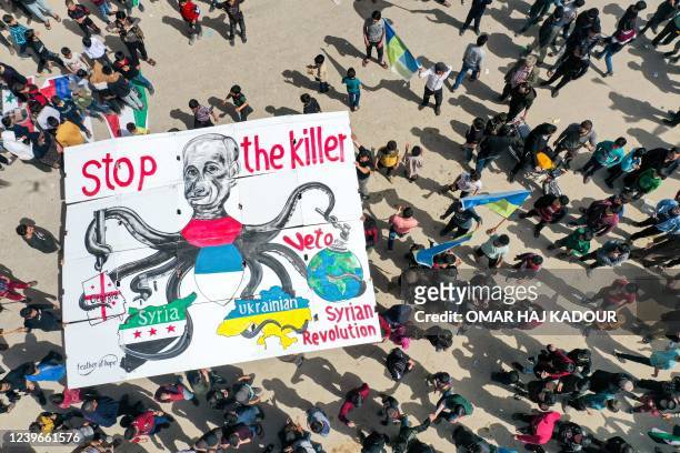 This picture taken on April 1, 2022 shows an aerial view of a giant sign being raised by protesters depicting Russia's President Vladimir Putin as an...
