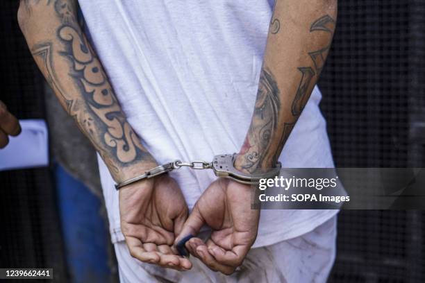 The arms of an MS-13 gang member are handcuffed while escorted into a detention center. On Sunday, March 27, the Salvadoran Congress approved a State...