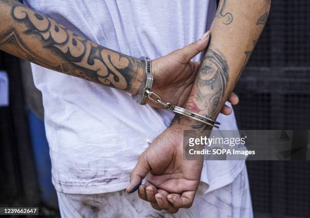 The arms of an MS-13 gang member are handcuffed while escorted into a detention center. On Sunday, March 27, the Salvadoran Congress approved a State...