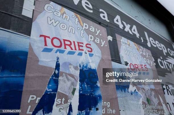 Badly torn protest poster in the city centre that reads "Can't pay, won't pay" over a graphic that reads "Tories" as the country's spiralling cost of...