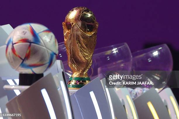 The FIFA World Cup trophy and the official 2022 World Cup ball called Al-Rihla, which means "the journey" in Arabic, are seen on stage during the...