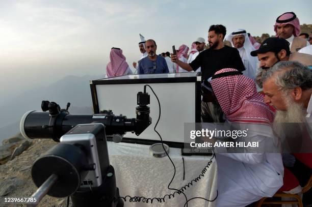 Saudis look at the sky to spot the first crescent of the moon marking the start of the Muslim holy month of Ramadan, in the southwestern Saudi city...