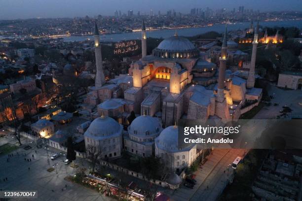 Illuminated messages, known as "mahya", hung between two minarets of the Hagia Sophia Grand Mosque and the Blue Mosque light up the night ahead of...