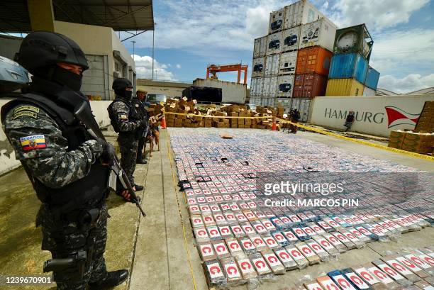 Ecuadorean anti-narcotics police stand guard next to packs of cocaine from a 3-ton shipment seized from a container of bananas, in the port of...