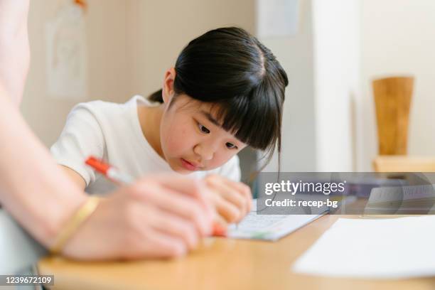 母と一緒に家で勉強している初等年齢の女の子 - kids learning at home ストックフォトと画像