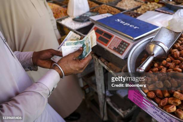 Vendor counts banknotes at a market in Islamabad, Pakistan, on Saturday, April 2, 2022. Pakistan Prime Minister Imran Khan said he will face a...