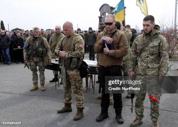 Soldier holds the urn with the ashes of an Azov regiment fighter Denis Kotenko , killed in action to liberate the village of Lukyanivka of the Kyiv...
