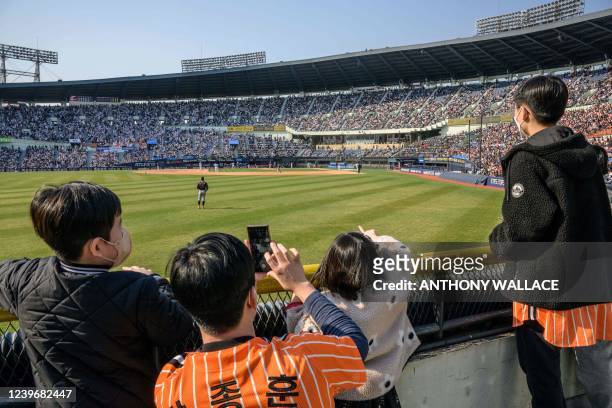 Supporters watch a match between Hanwha Eagles and Doosan Bears on the first day of the 2022 Korea Baseball Organization season at Jamsil Baseball...