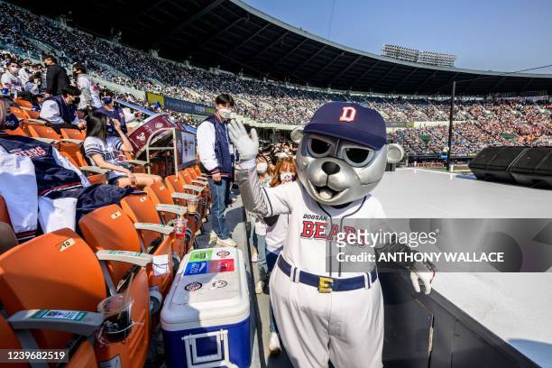 Performer dressed as a team mascot of the Doosan Bears reacts during a match between Hanwha Eagles and Doosan Bears on the first day of the 2022...
