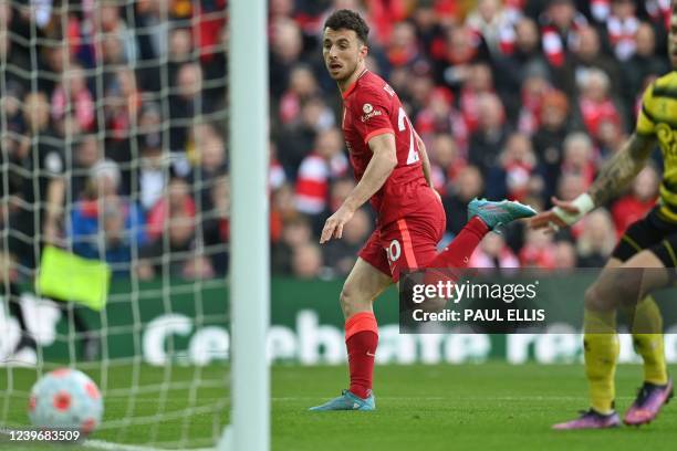 Liverpool's Portuguese striker Diogo Jota sees his glanced header cross the line for Liverpool's first goal during the English Premier League...