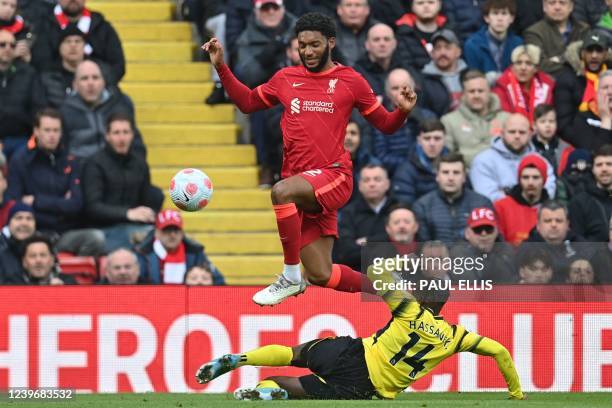 Watford's Ivorian defender Hassane Kamara slides in to tackle Liverpool's English defender Joe Gomez during the English Premier League football match...