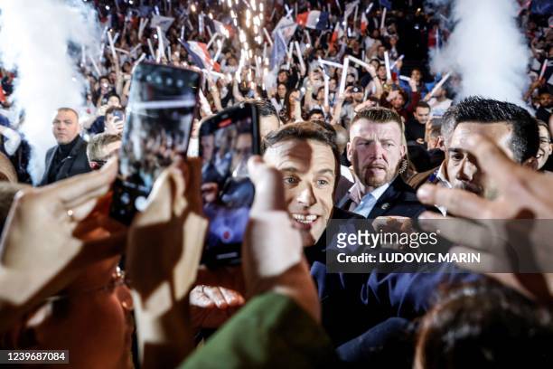 French President and liberal party La Republique en Marche candidate for re-election Emmanuel Macron salutes people as he arrives for his first...