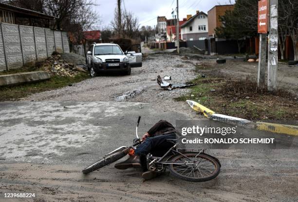 Graphic content / TOPSHOT - The body of Mykhailo Romaniuk lies next to his bicycle on Yablunska street in Bucha, northwest of Kyiv, on April 2, 2022....
