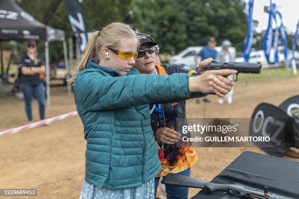 Young woman shoots with a CZ Shadow 2 9mm pistol during a gun show event for women with more than 140 participants in Bronkhorstspruit, South Africa...